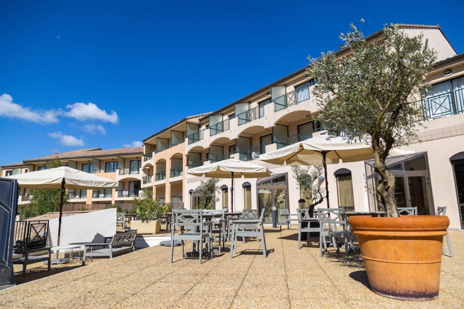 Spacious outdoor terrace event space with dining tables, parasols