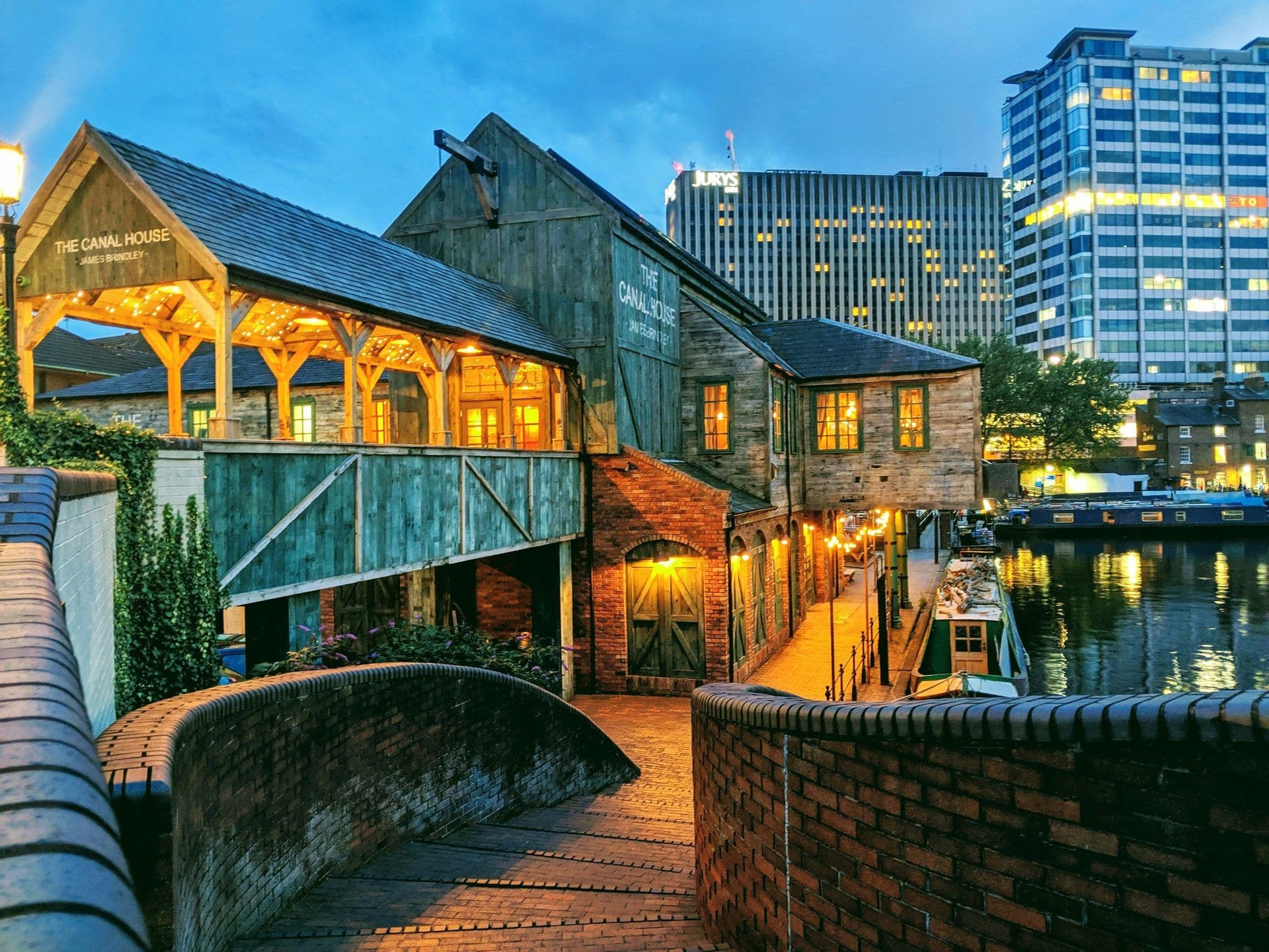 The Canal House, a rustic canal-side event venue in Birmingham, illuminated at dusk with string lights.