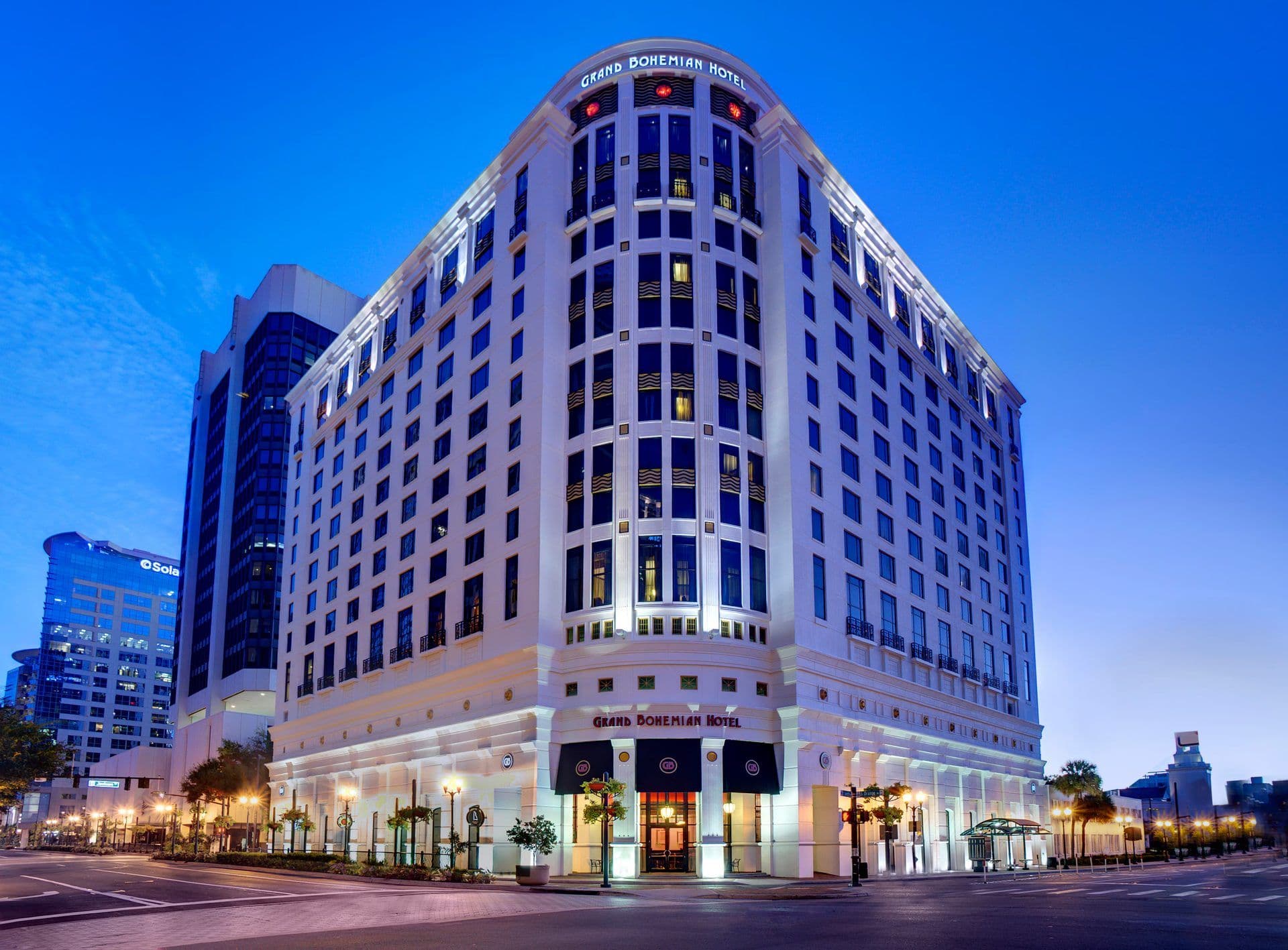 Exterior view of the Grand Bohemian Hotel, an elegant corporate event venue, lit up at twilight in Orlando.