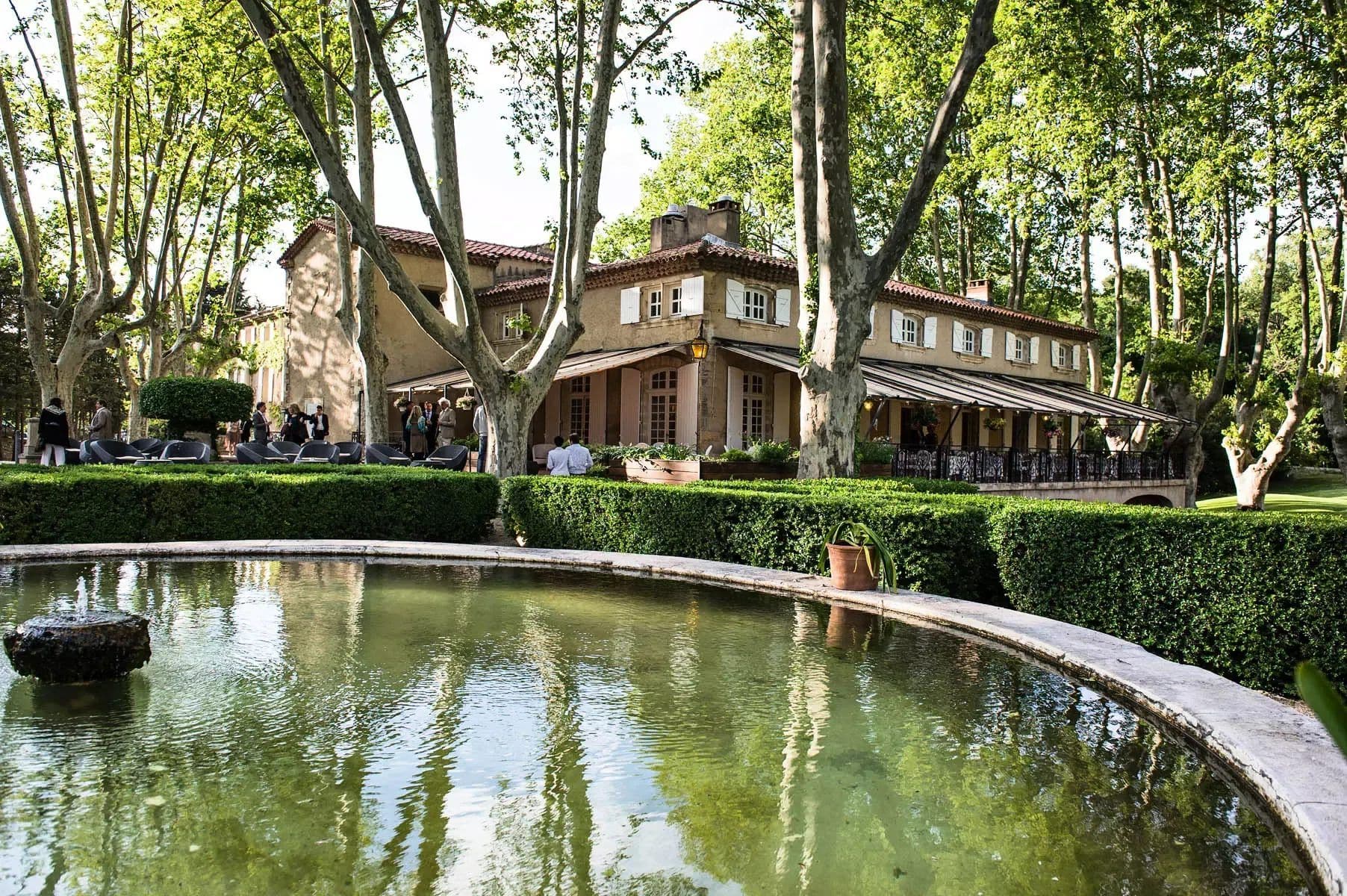 Historic corporate event venue with an outdoor terrace, lush gardens, and a pond for networking.