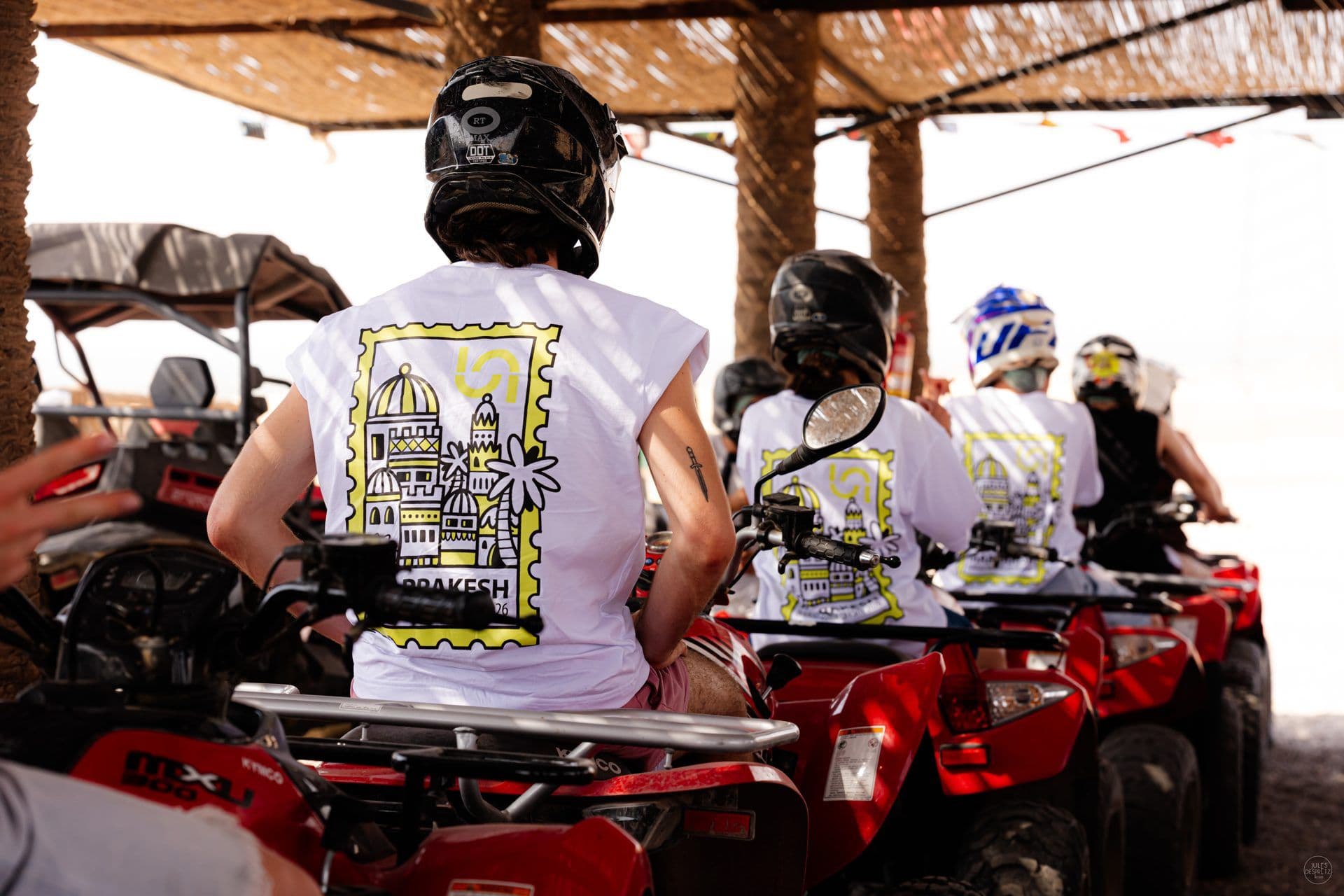 A row of Naboo colleagues on quad bikes in the Agafay desert, each wearing the Marrakesh offsite T-shirt