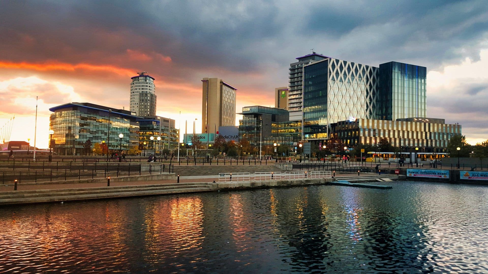 MediaCityUK's modern corporate event venues and offices reflect a colorful sunset over Salford Quays