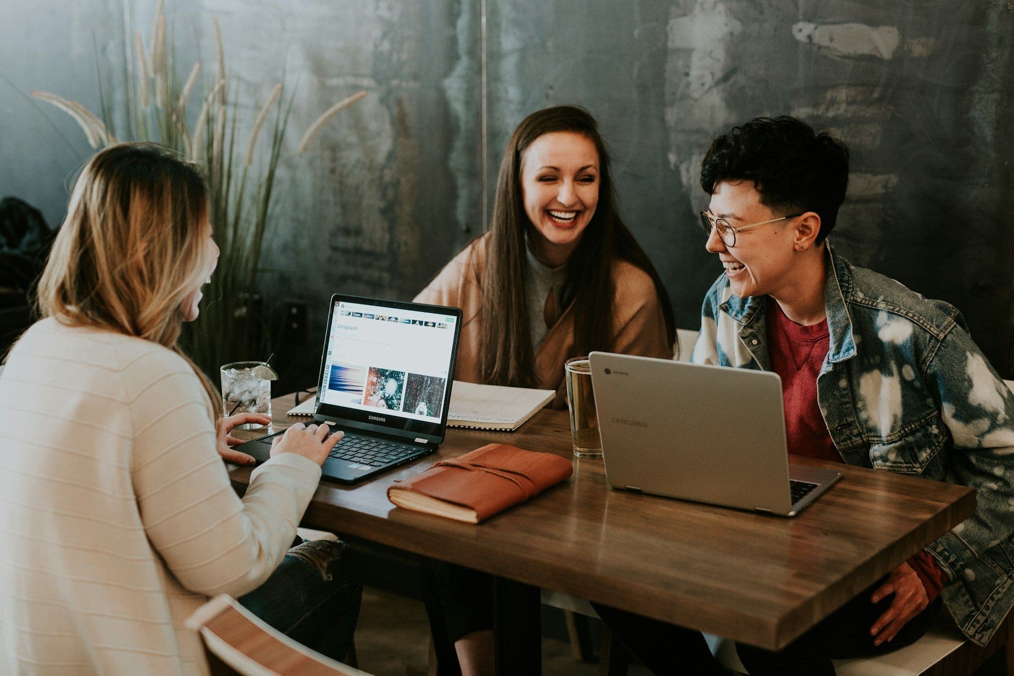 Team members laughing together at a table on their first day back at work