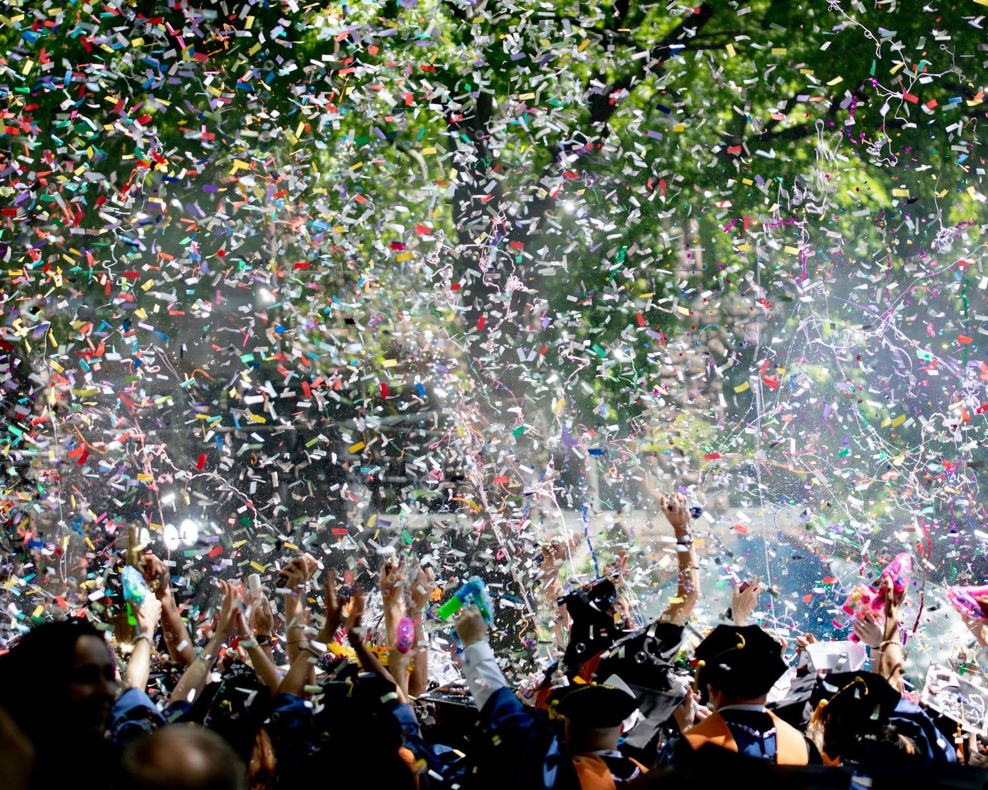 Team members covered in colorful confetti at a New Year's Eve celebration