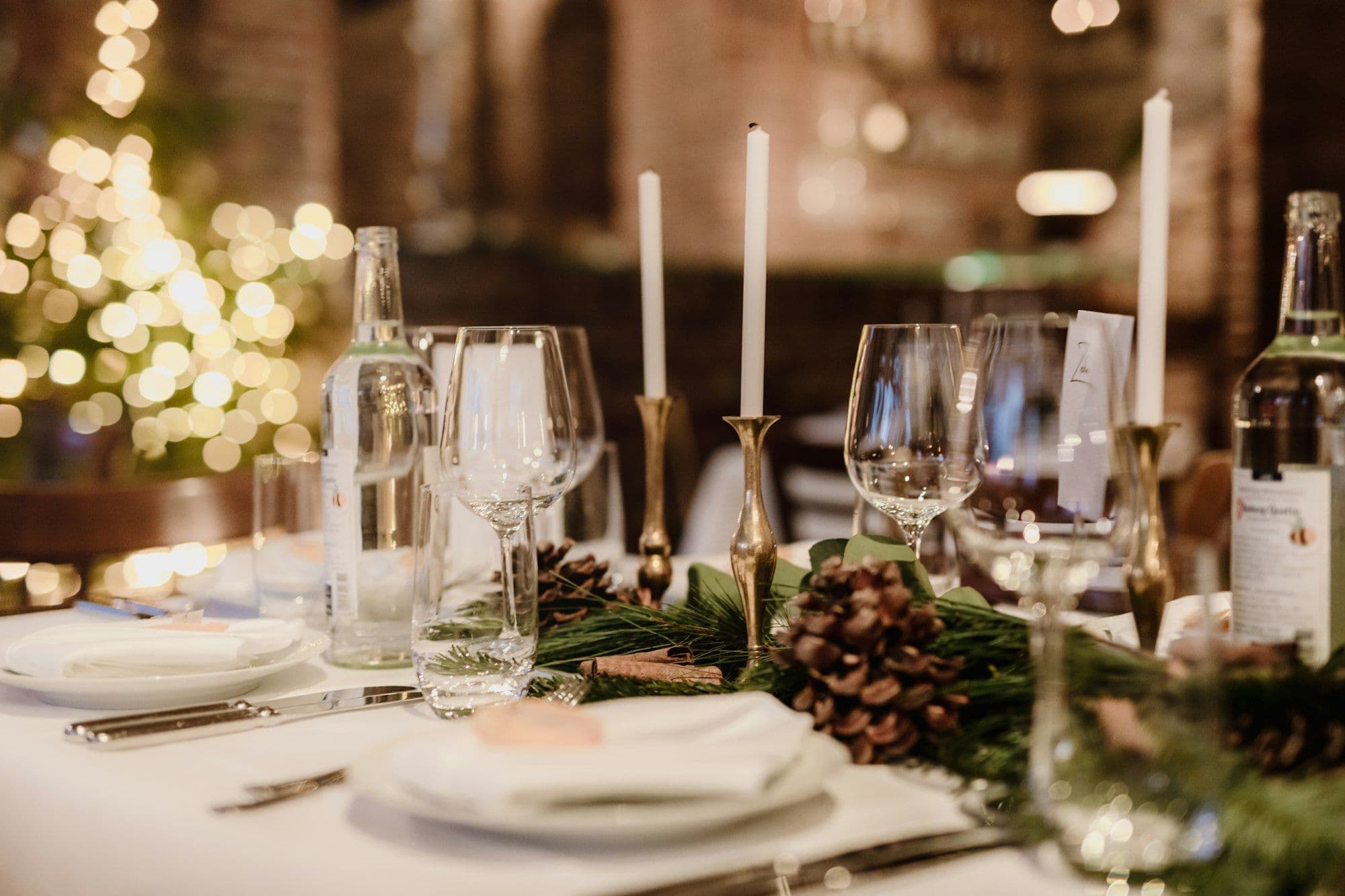 An elegantly set dinner table with wine glasses for a company Christmas dinner