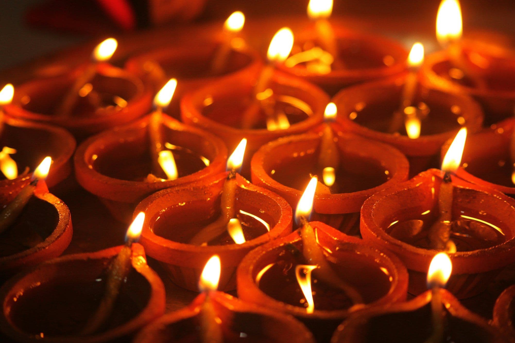 A row of lit diya-style candles for a workplace Diwali celebration
