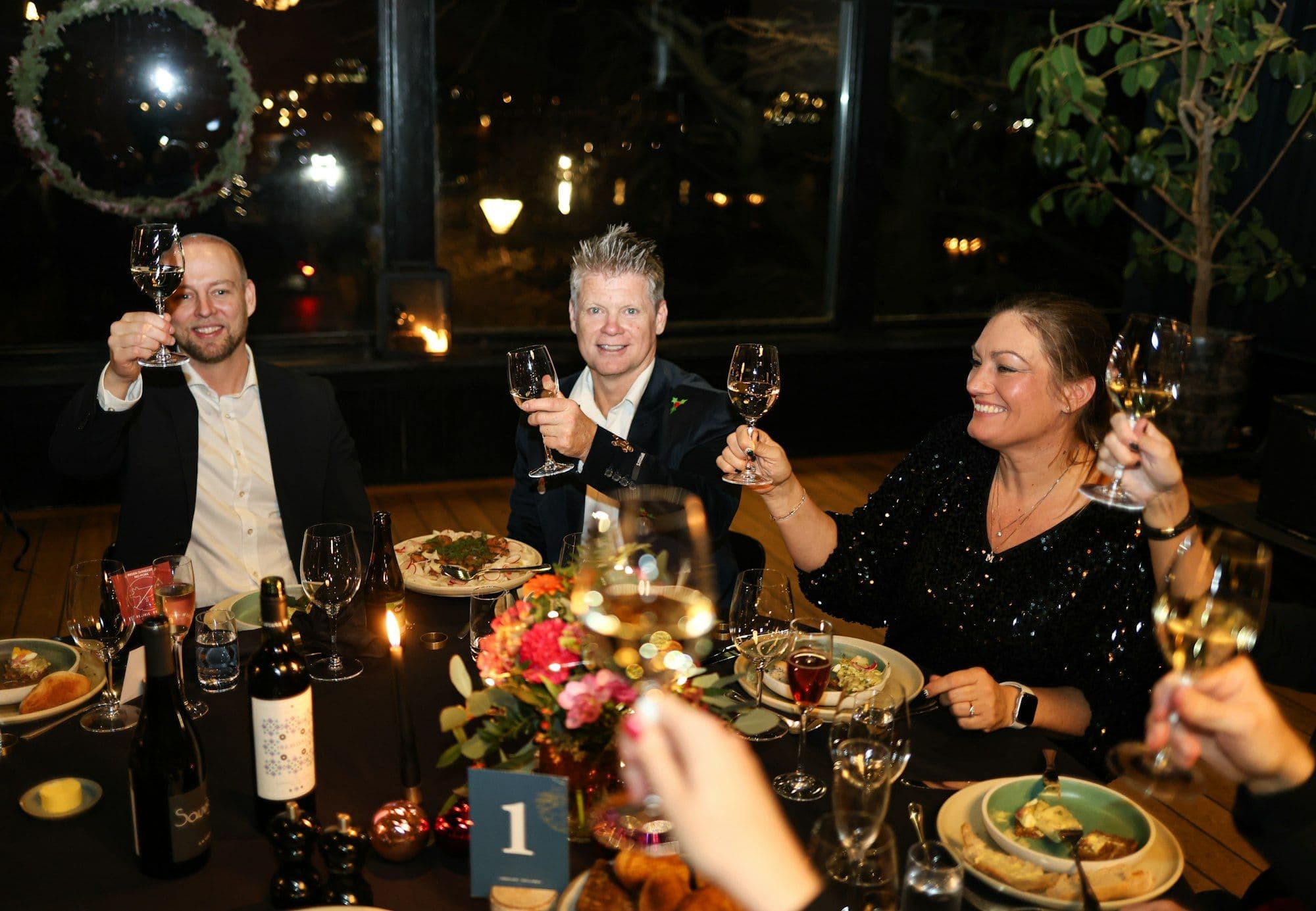 Colleagues toasting with wine glasses at a New Year's Eve gala dinner