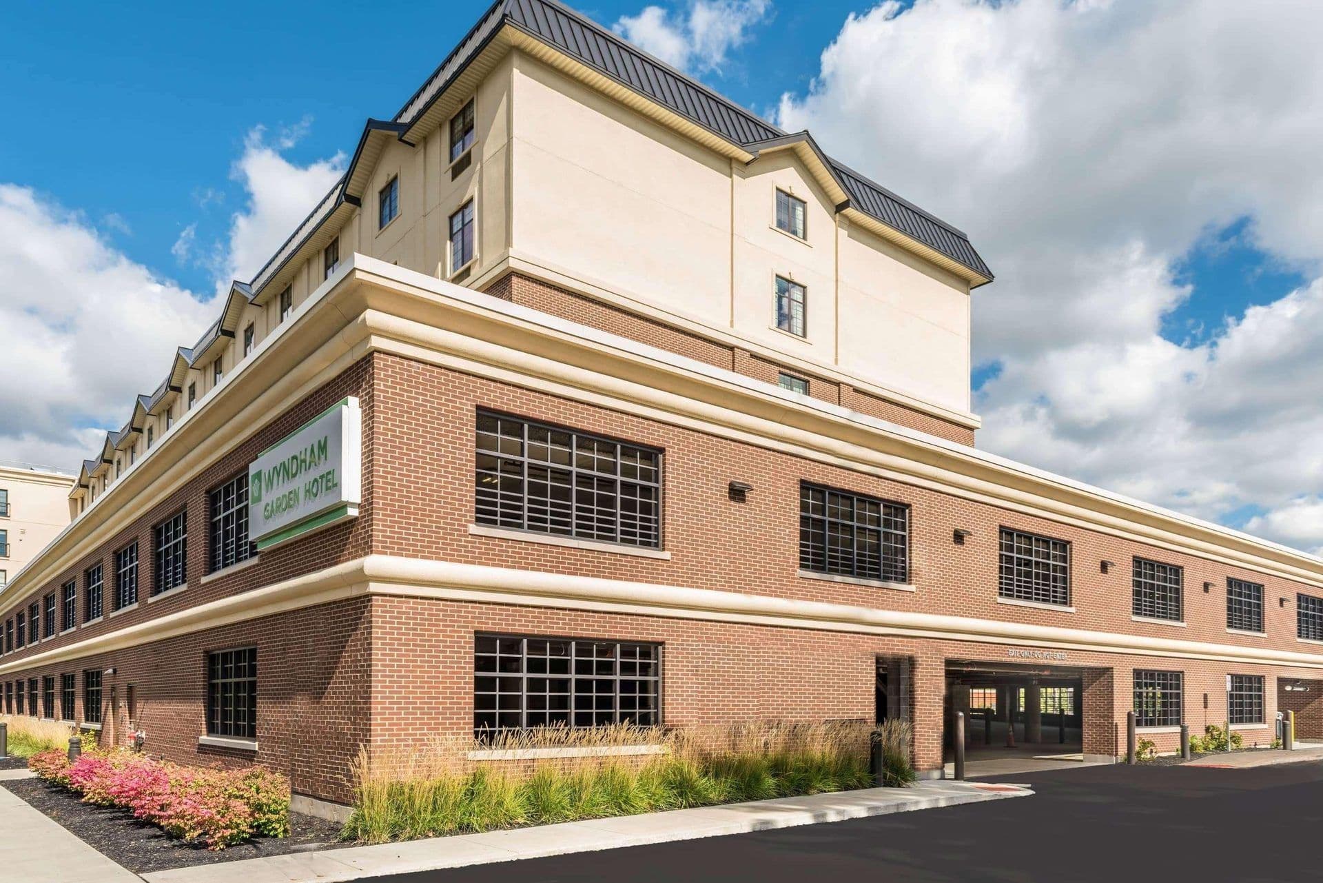 Exterior of the Wyndham Garden Hotel, a corporate event venue with brick facade and parking garage.