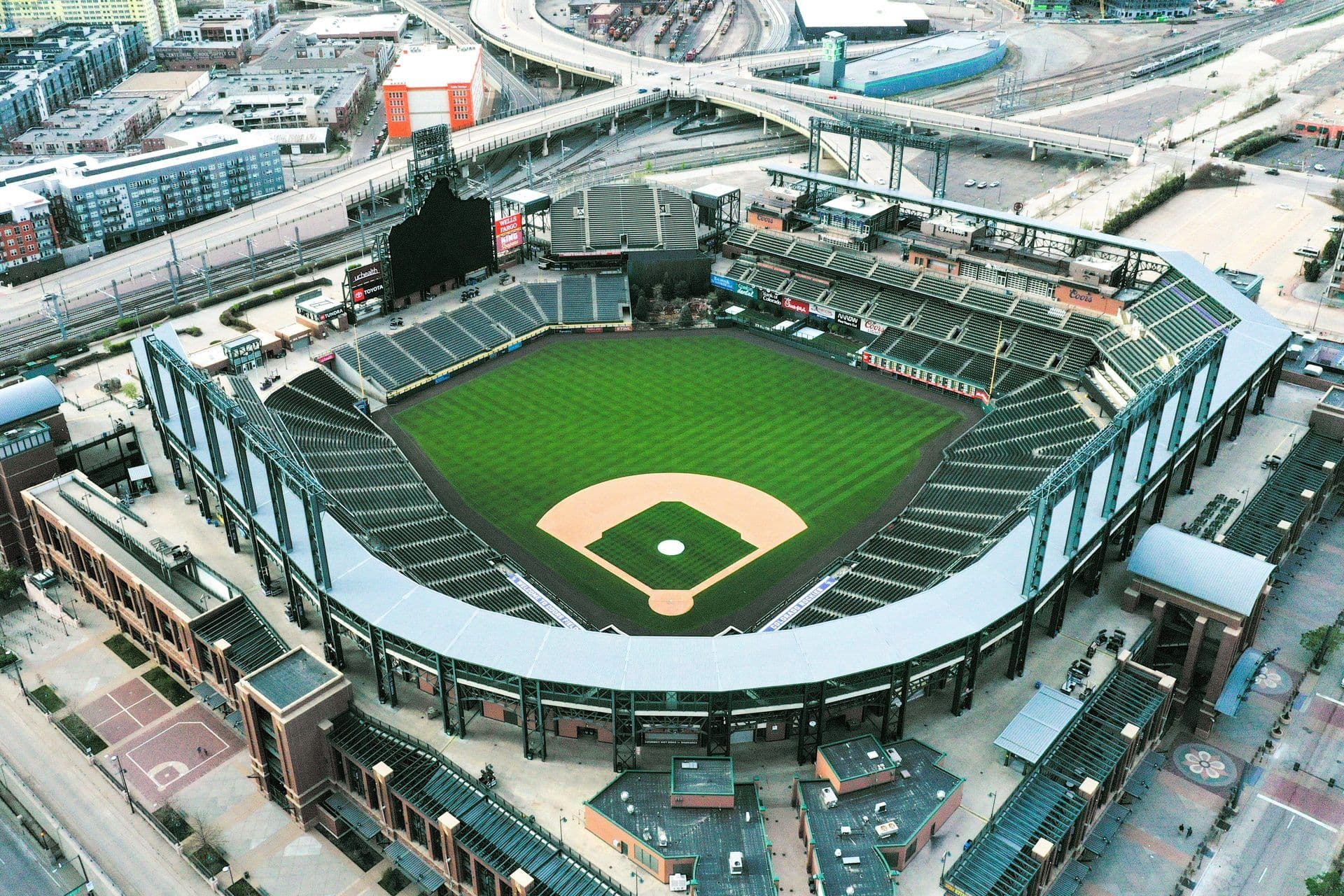 Aerial view of a large baseball stadium with a green field and empty seats