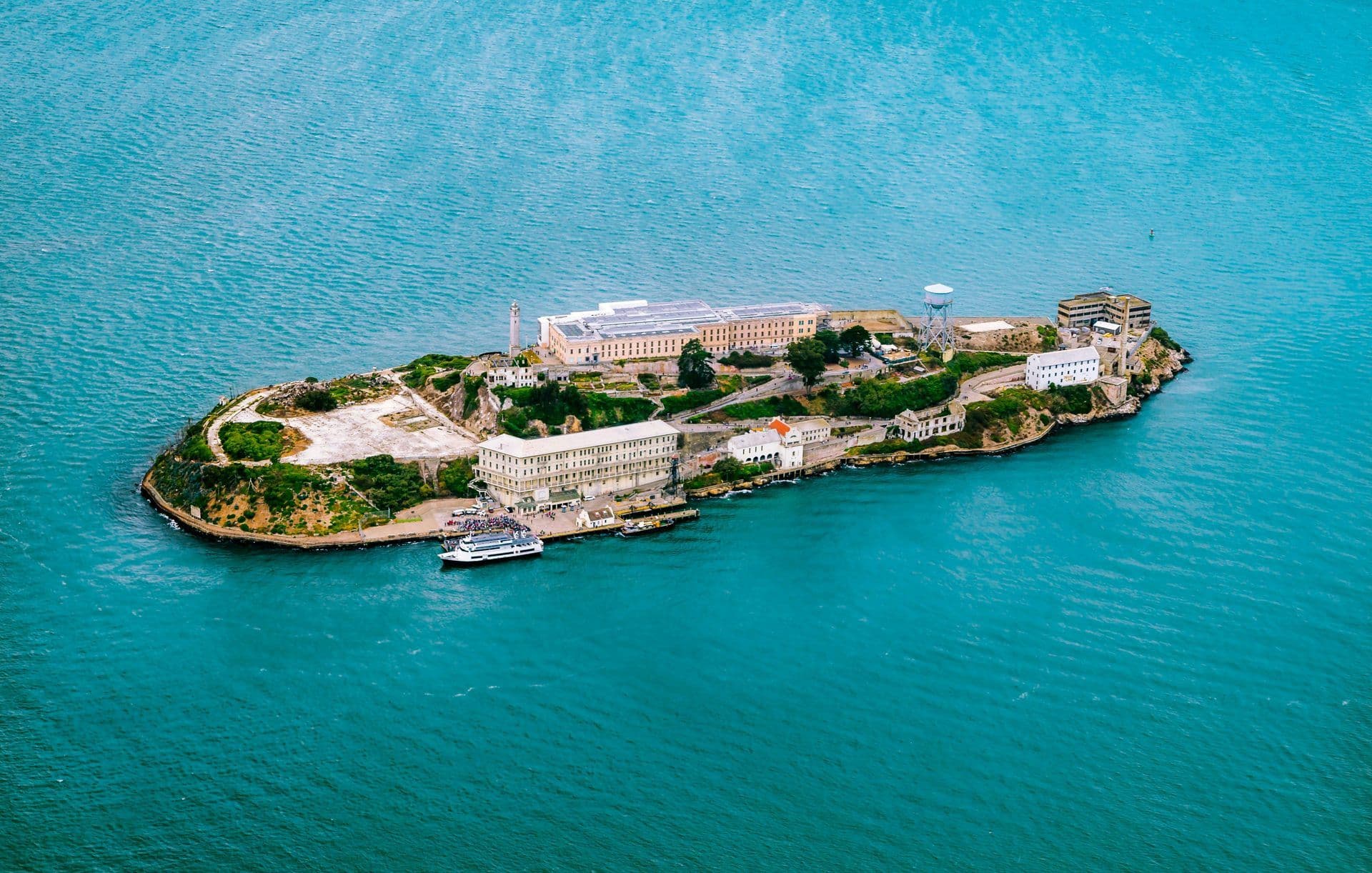 Aerial view of Alcatraz Island in San Francisco Bay, a historic waterfront venue with a ferry docked.
