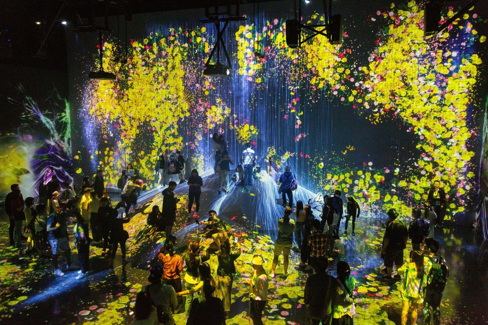 Large group enjoying an immersive digital art experience in a unique corporate event venue.
