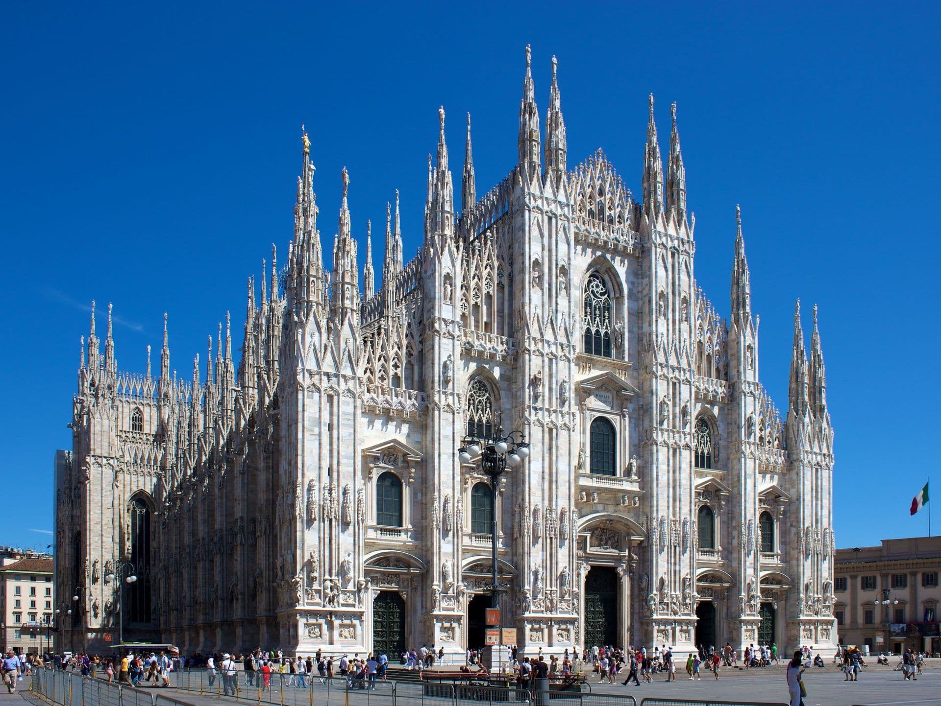 The grand Milan Cathedral (Duomo di Milano) in Italy, a historic Gothic landmark under a clear blue sky.