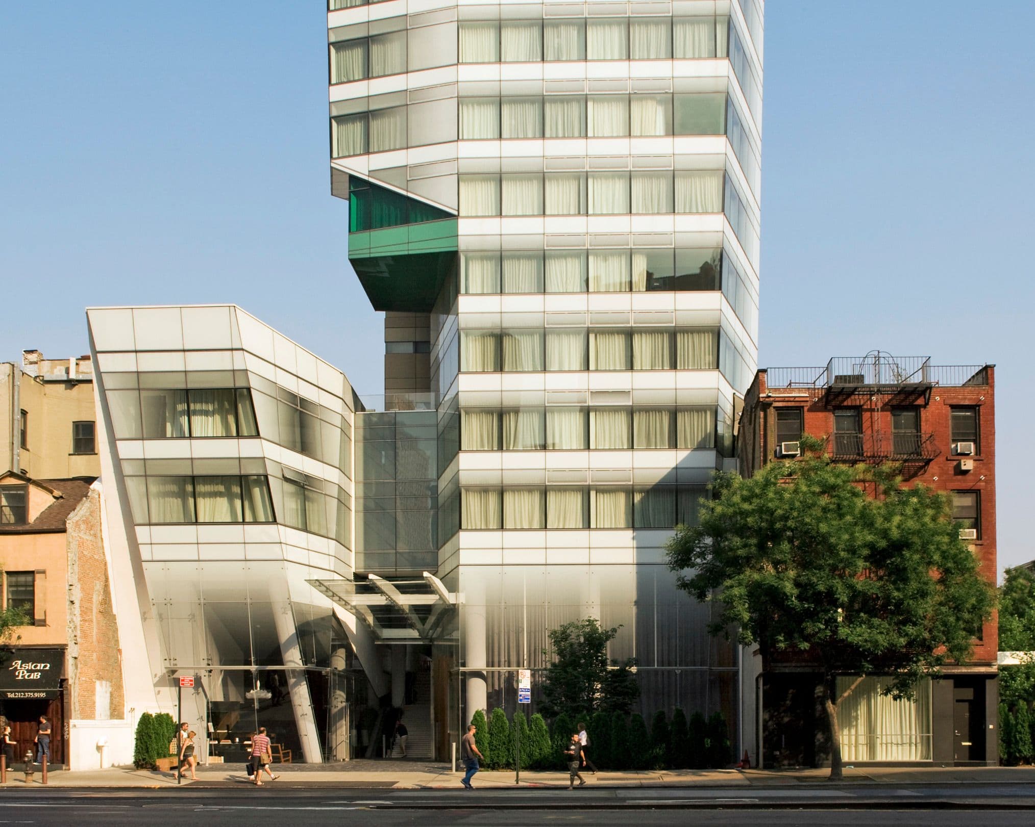Modern glass-fronted corporate event venue in New York City with people walking on the sidewalk.