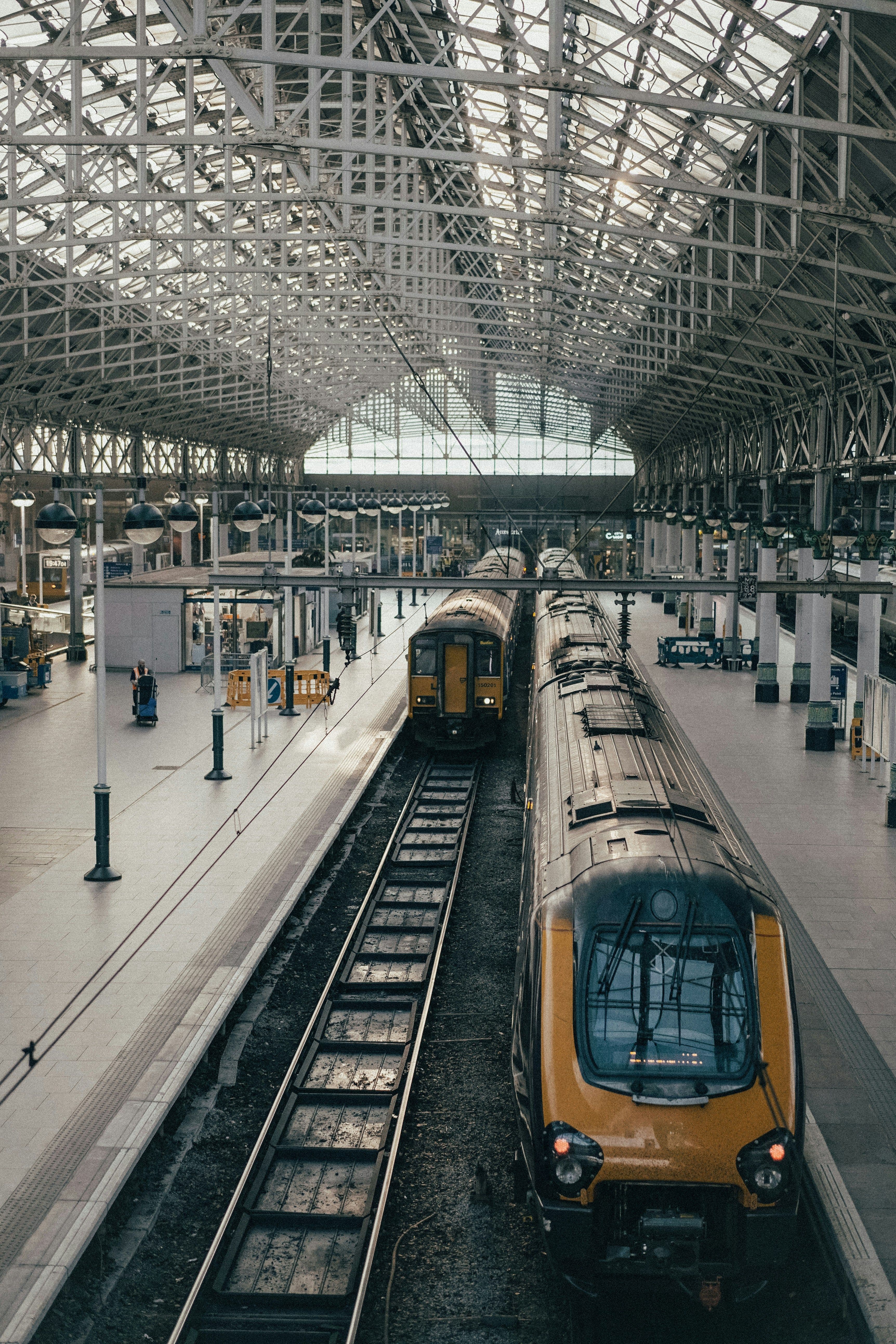 Trains waiting under a historic station roof