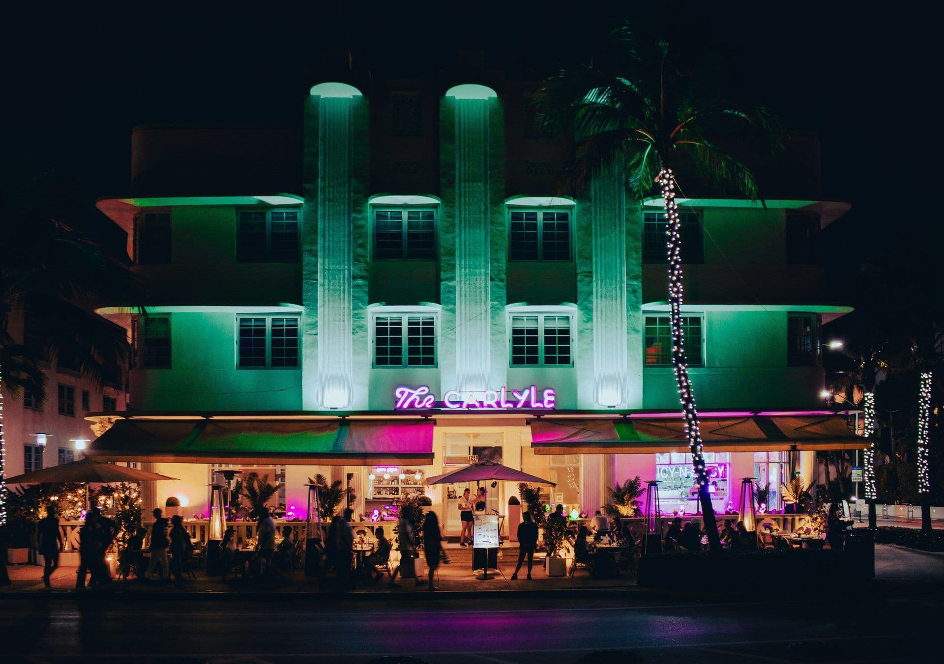 Art Deco Carlyle hotel in Miami Beach with vibrant neon lights and an outdoor corporate dinner venue.